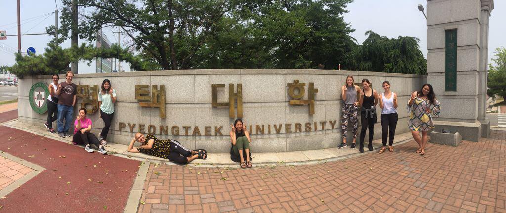 Students sitting in front of Pyeongtaek University sign