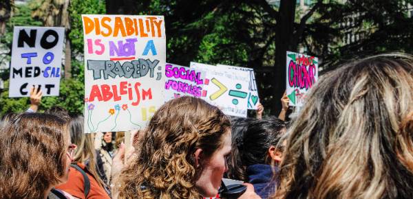 Posters being raised in a group during 2025 Lobby Days 